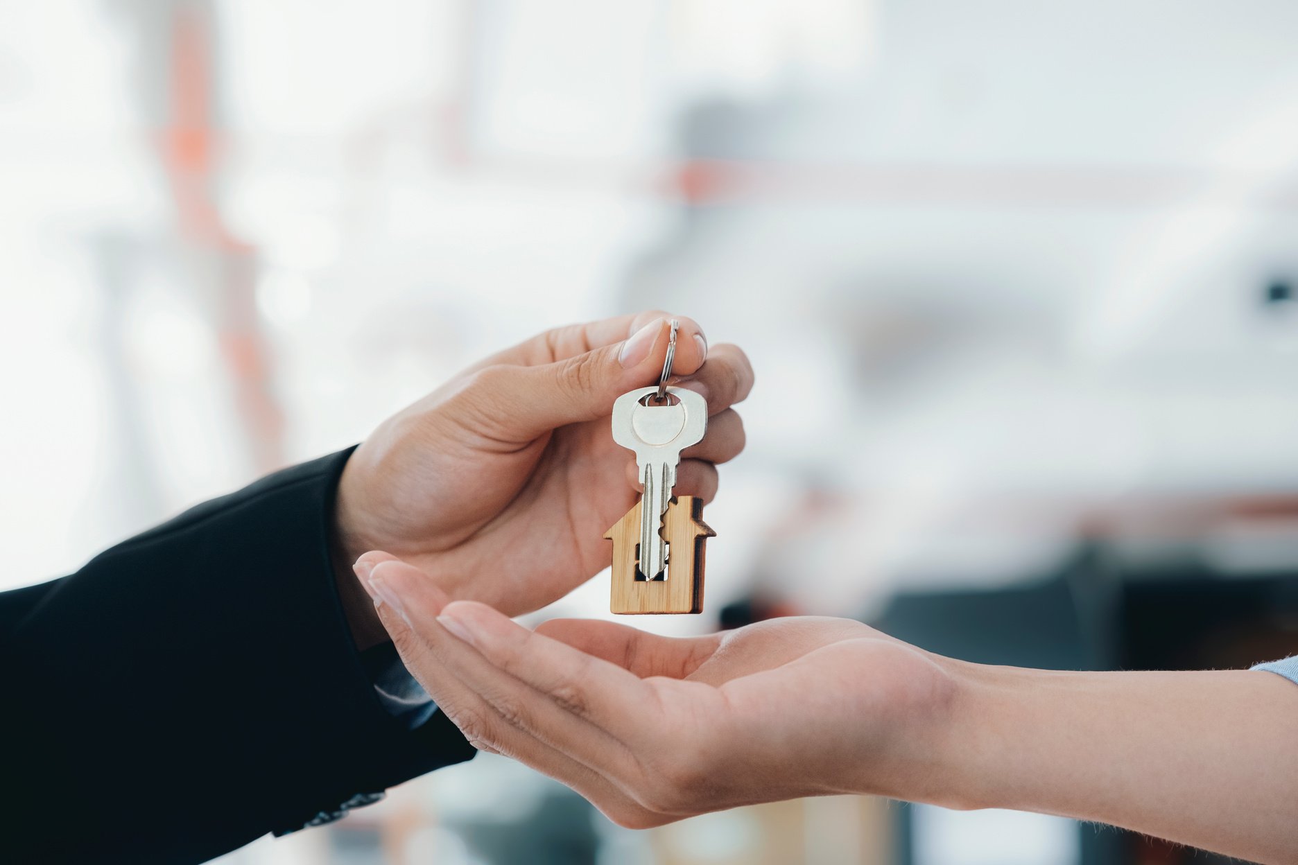 Agent's Hands Giving House Keys to Customer